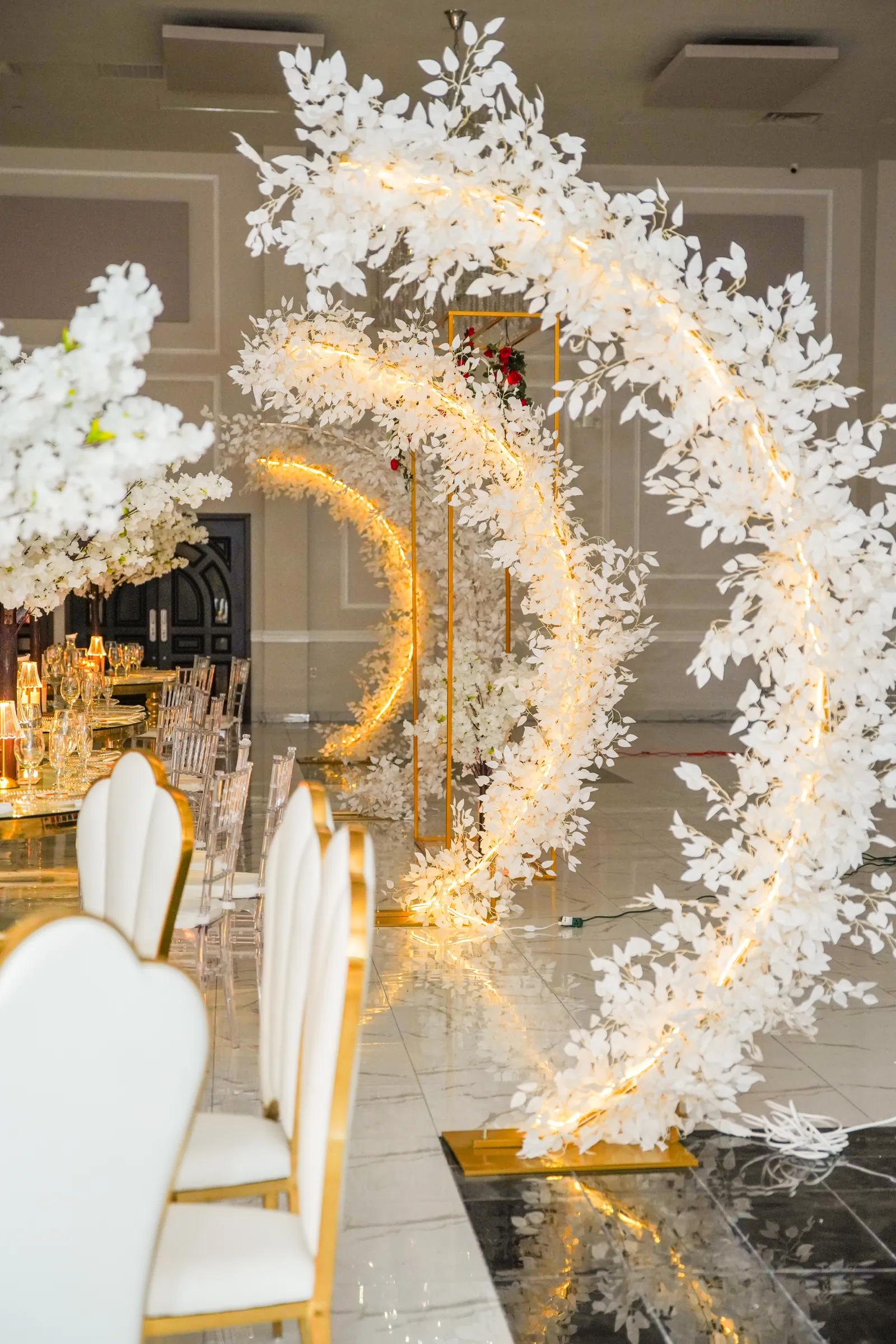 Illuminated floral arch beside the head table