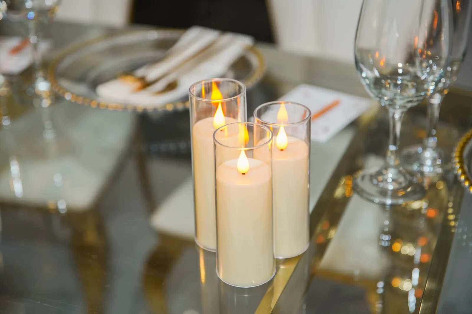 Candles and glassware on a mirrored table top