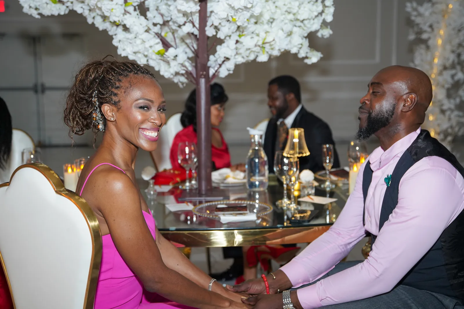 Guests at a dinner table beneath blossom centrepieces