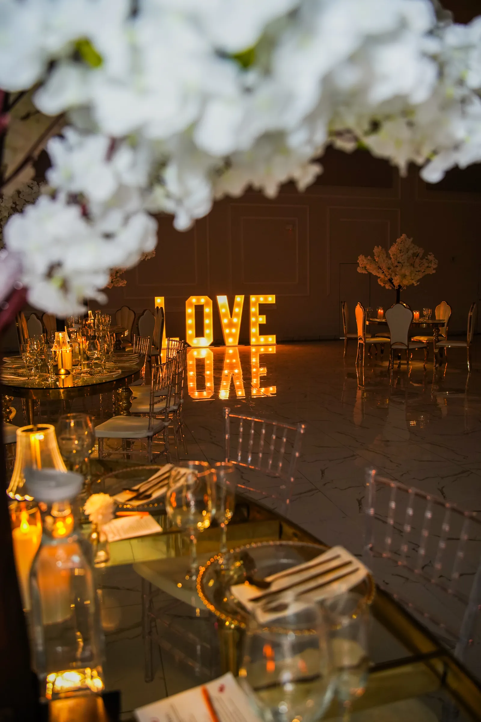 Marquee letters and blossom above a candlelit table