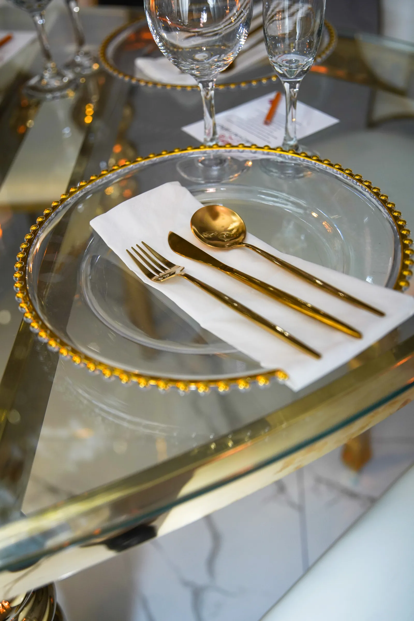 Gold place setting with folded napkin and cutlery