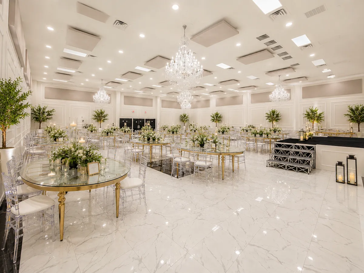 Main banquet hall set with round tables, gold chairs and crystal chandeliers